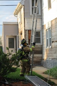 Firefighter Andrew Beiler raises a ladder at an acquired structure training.
