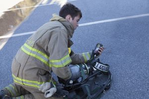 Junior Firefighter Arlan Miller checks a gauge on his new air pack. The cylinders are industry standard with 4500 psi.